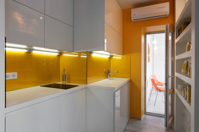 кухня в дизайне квартиры-студии в оранжево-белых тонах