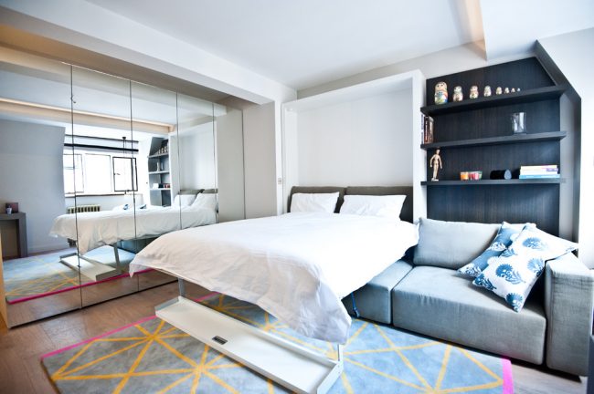 Даже дизайн спальни-гКровать-трансформер, которая прячется в стене, отлично сэкономит пространство в маленькой спальне-гостинойостиной площадью 18 кв. м может быть очень уютный и красивый