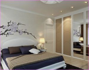 Данная спальня украшена рисунком на обоях и потрясающим светильником