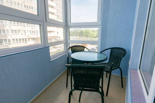 Стол и три стула на балконе в квартире многоэтажного многоквартирного дома — стоковое фото